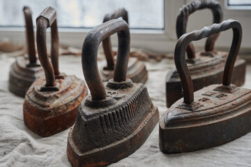 conceptual photography - a set of antique cast iron irons on the surface of a canvas lying on a windowsill symbolizing group relationships