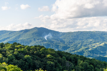 Sugar Mountain ski resort town view of Beech mountain and smoke rising from fire burning wildfire forest in North Carolina Blue Ridge Appalachia summer - obrazy, fototapety, plakaty