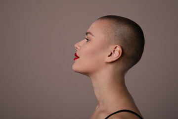Close-up portrait of beautiful bald young woman, posing in the studio. Isolated.