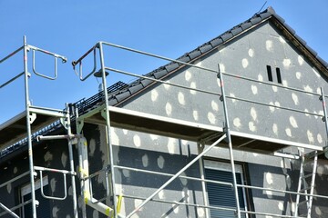 Ger&uuml;st an einem neu gebauten Wohnhaus im Rohbau in einem Neubaugebiet