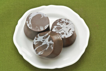 Chocolate em um prato branco em fundo verde