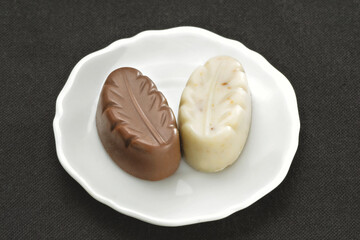 Chocolate em cima de um prato branco no fundo escuro