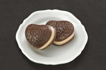 Chocolate em cima de um prato branco no fundo escuro