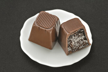 Chocolate em cima de um prato branco no fundo escuro