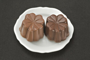 Chocolate em cima de um prato branco no fundo escuro