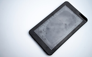 Moisture ingress into the electronic tablet. Repair of equipment. A broken tablet on a white isolate.