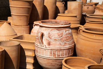 A large variety of orange terracotta pots set outside to dry