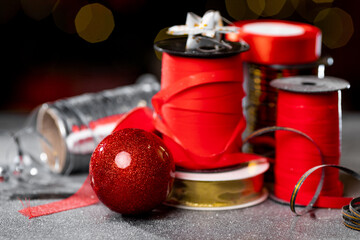 Christmas different ribbon spools for decorating gifts on a dark background with bokeh