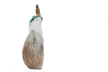 A leg of a Spanish serrano ham, upright, wrapped in paper. Isolated on white background.