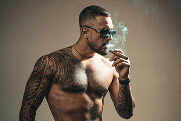 Brutal man smoking cigar, serious face of handsome male model, concept of men power and strong....