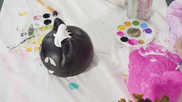 Painting craft pumpkin with acrylic paint for Halloween.