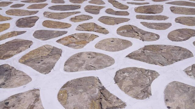 Traditional cobblestone white painted pattern pavement found on many Greek Islands in the Aegean Sea
