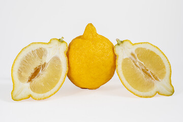 One lemon and two halves on a white background.