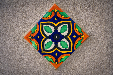 2021-12-03 MULTI COLORED CERAMIC TILE ON A WHITE STUCCO WALL