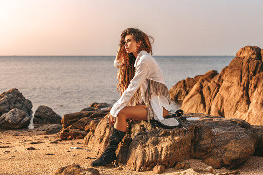 beautiful young fashionable woman on the beach at sunset