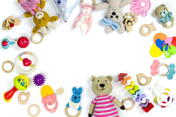 Various children's toys and rattles are scattered on a white background with copy space. Children's...