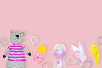 Miscellaneous baby things on a pink background with copy space.