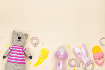 Knitted bear, wooden toys, combs and other baby things on a light background with copy space.