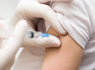 Fototapeta na wymiar Close up of a Doctor making a vaccination in the shoulder of patient, Flu Vaccination Injection on Arm, coronavirus, covid-19 vaccine disease preparing for human clinical trials vaccination shot.