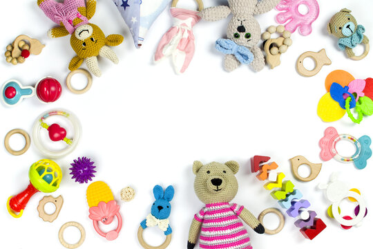 Various children's toys and rattles are scattered on a white background with copy space. Children's background.