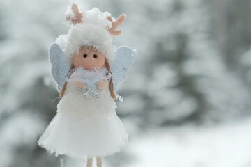 Winter angel.Christmas and New Years time.Christmas angel on a snowy tree. Christmas tree toy.