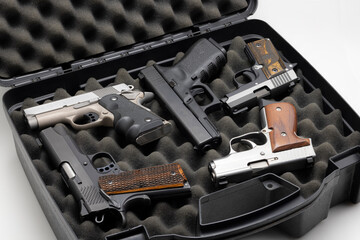 Automatic handguns collection in a plastic hard case on white background - obrazy, fototapety, plakaty
