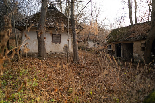 Semi-destroyed stone abandoned buildings in traditional ukrainian style in the village. Old stone adobe house with entrance shed and roof of stone slabs. Ukraine