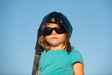 Kids dream. Funny child with pilot helmet and glasses, funny face close up. Kids head portrait.