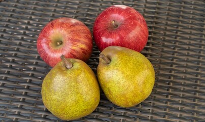 ラタンのテーブルに置かれた2個のリンゴ（りんご）とラフランス