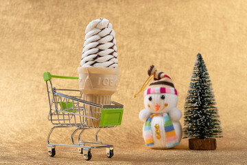 ice cream cone in a shopping cart with Christmas tree and snowman nearby