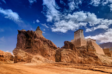 Fototapeta premium Ruins and Basgo Monastery surrounded with stones and rocks , Blue sky with clouds in the background, Himalayan Mountain range, Leh, Ladakh, Jammu and Kashmir, India