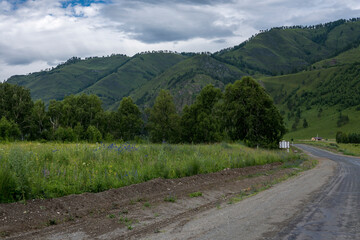 Fototapeta na wymiar asphalt road between mountain peaks. warm summer day