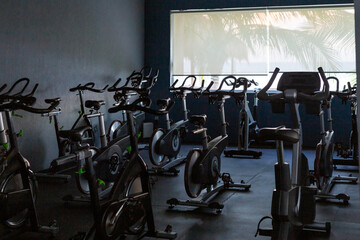 Vue sur un gym intérieur avec vélos stationnaires installés à côté d'une fenêtre avec vue...