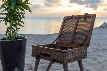 Table en forme de coffre sur patte ouvert sur une plage lors d'un coucher de soleil