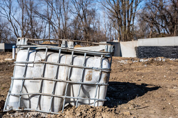 Abandoned damaged bulk plastic tote at an industrial construction site