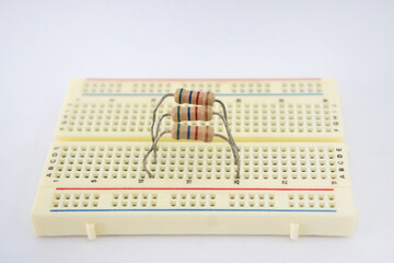 Fixed resistors connected in Parallel electrical circuit on a protoboard, on white background....