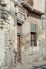 Grunge stone bricks wall with Broken wooden door and closed broken window in abandoned district