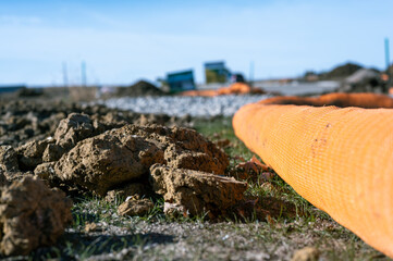 selective focus on filter sock around exposed dirt at a construction site to prevent stormwater erosion and runoff 