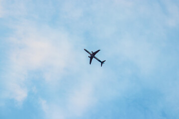 Single plane flying across a cloudy blue sky day