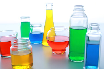 色の付いた水が入った瓶やコップ