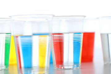 色の付いた水が入った瓶やコップ