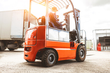 A man on a forklift works in a large warehouse, unloads bags of raw materials - obrazy, fototapety, plakaty