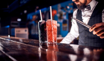 Confident bartender makes a show creating a cocktail in the bar
