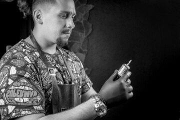 Tattooer poses in tattoo parlour