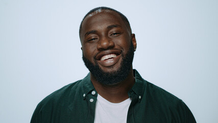 Closeup african handsome guy smiling at camera in studio. Afro man posing