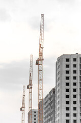 Fototapeta na wymiar Three Construction crane on a cloudy sky