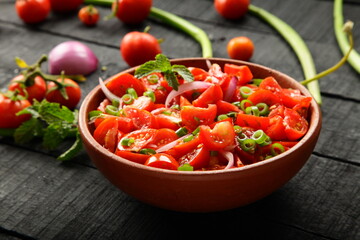 Homemade delicious fresh organic tomato salad with exotic herbs.