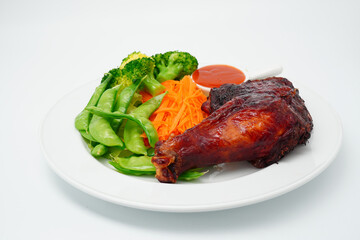 Grilled chicken marinated with spices and boiled fresh vegetables Broccoli, green peas, lettuce in a white plate