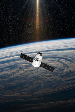 Cargo space craft and Earth planet. Dark background. Sci-fi wallpaper.Space Station Orbiting Earth.Space ship. Space art wallpaper.Solar Observatory.Elements of this image furnished by NASA.