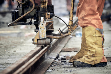 Construction worker using machine for steel train tracks.